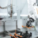 Ramię robota przemysłowego wykonujące precyzyjne operacje w nowoczesnej fabryce